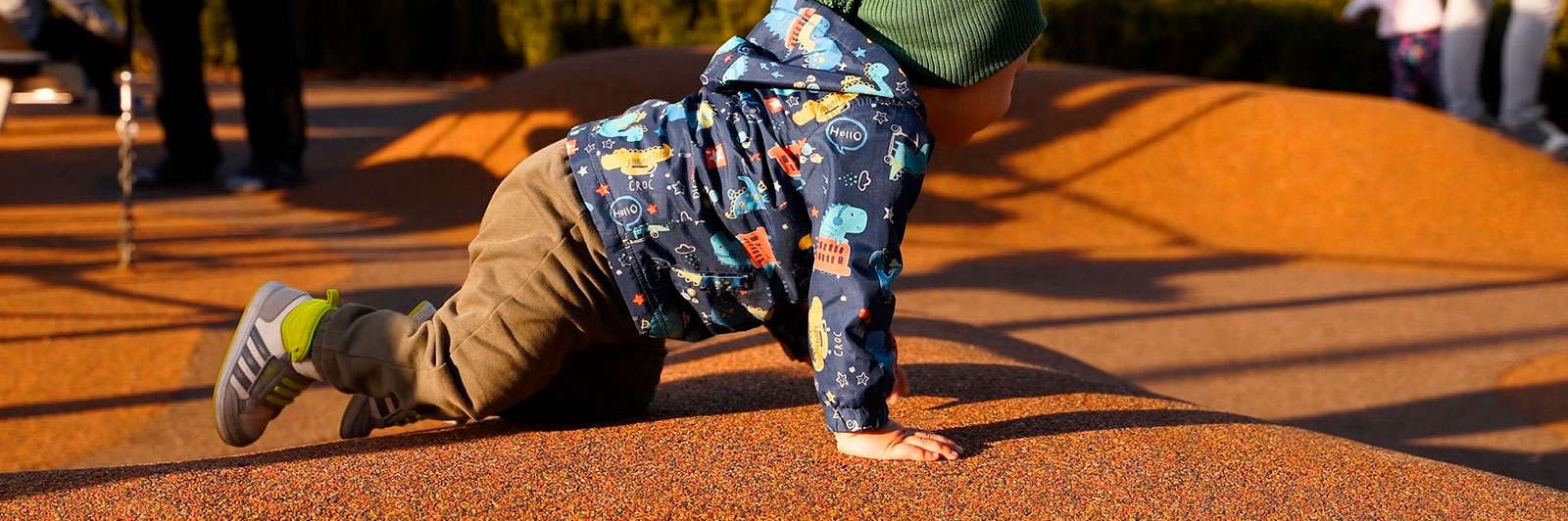 Un petit garçon rampant sur un revêtement en caoutchouc.